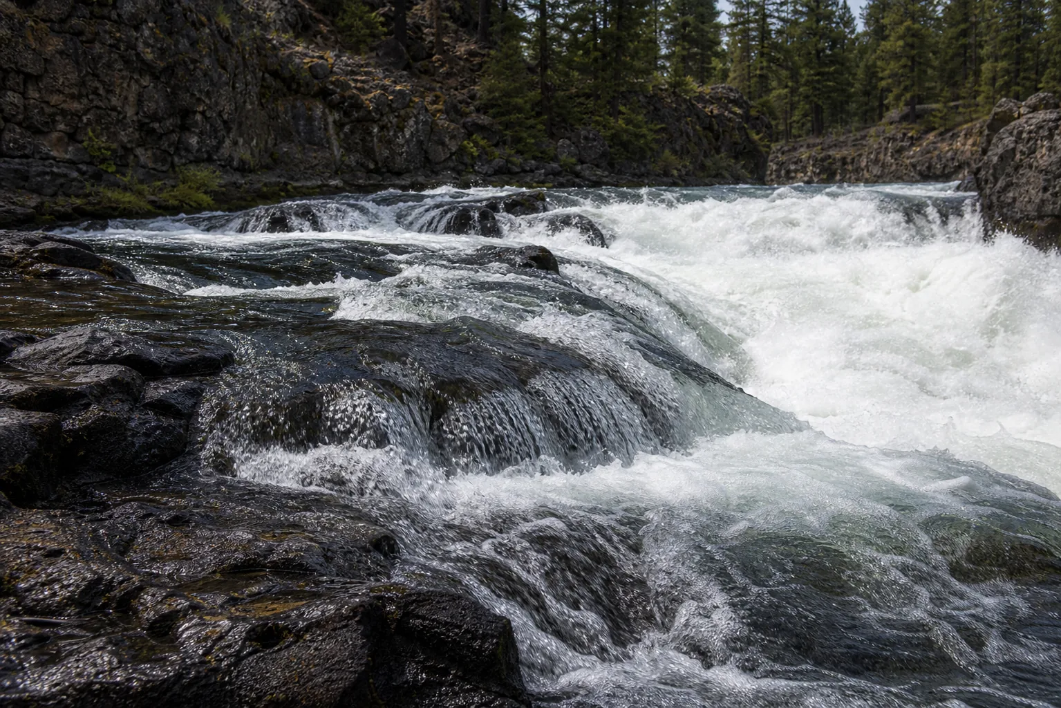 Close detail of the Deschutes River white water crossing the Lava Butte basalt steps at Benham Falls