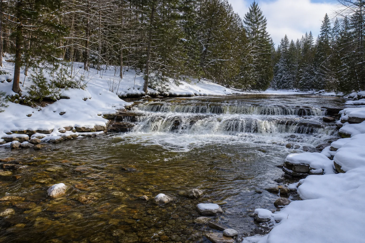 Ocqueoc Falls wide setting view of the ocqueoc river cascade and surrounding northern hardwood forest