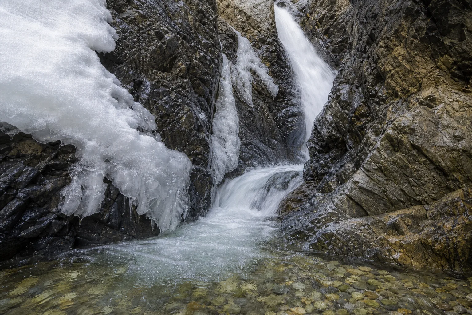 Zapata Falls water and ancient gneiss bedrock detail inside the slot canyon